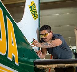 A student working on a plane. Links to Gifts That Protect Your Assets